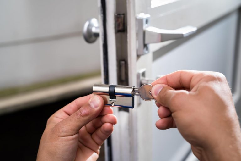 Cylindre de serrure et clé entre les mains d'un serrurier